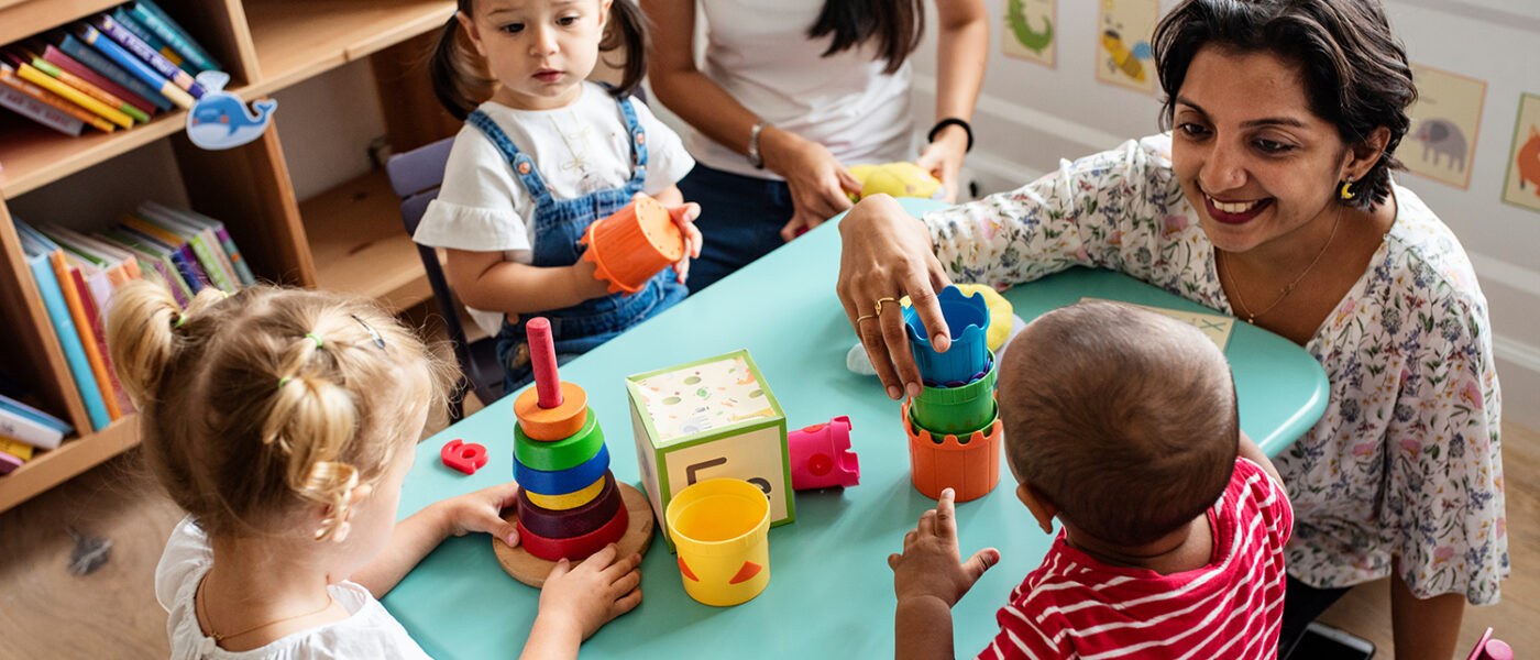 Nursery children playing with teacher in the classroom at Bright Horizons Daycare at Santa Monica Business Park.